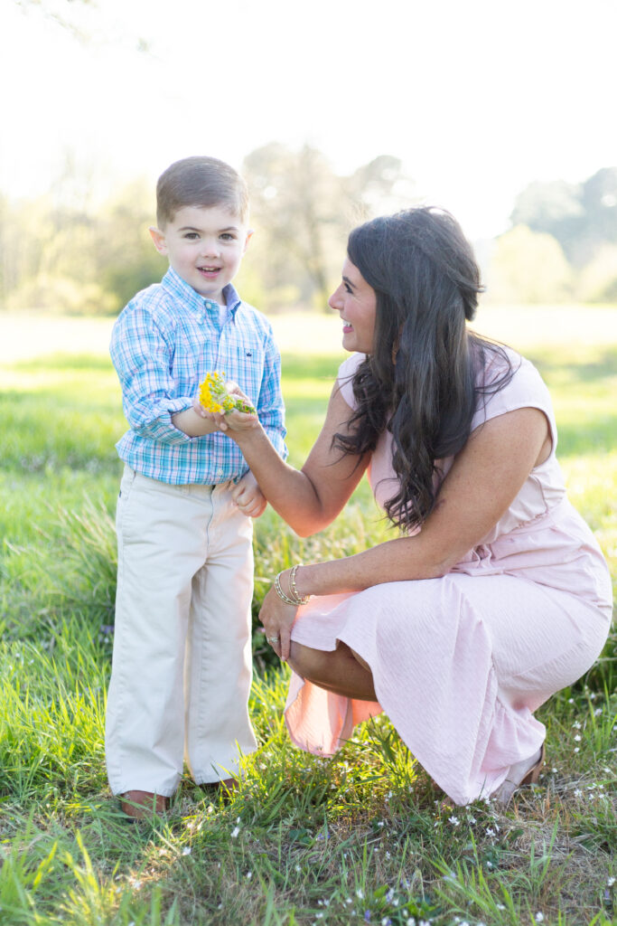 little boy  handing his mom a yellow flower.  outdoor photo session in birmingham, alabama
