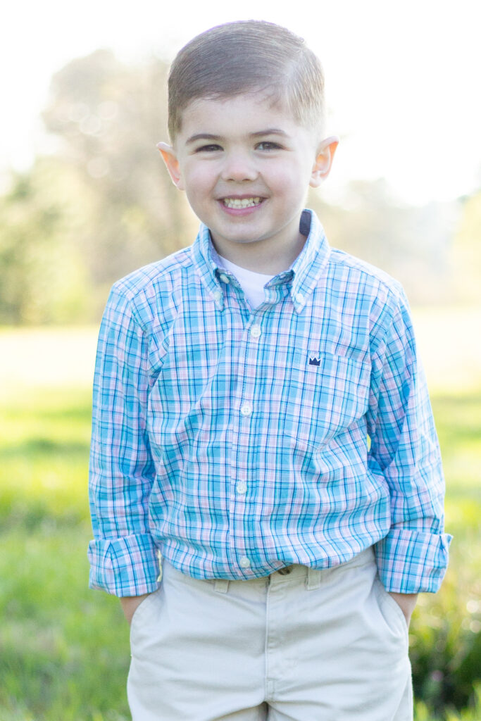 little boy smiling, hands in his pockets, outdoor photo session, hoover, alabama